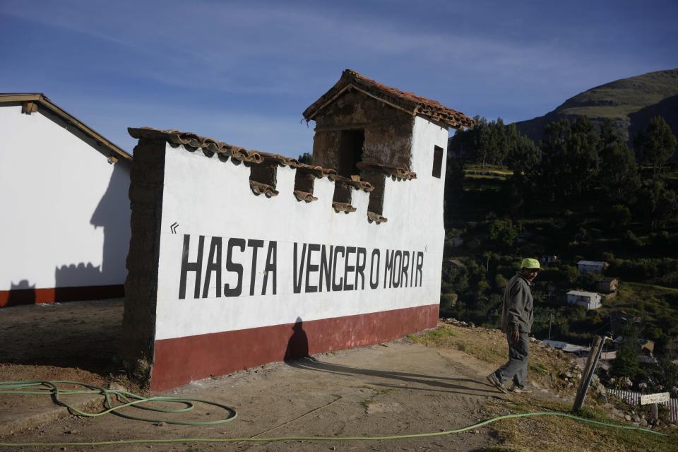 The Spanish phrase "Until we overcome or die" covers an empty cemetery, which used to be an army base, where the remains of victims killed during the Maoist-inspired insurgency will be the first to be buried here, days after the remains were turned over to families in Accomarca, Peru, Thursday, May 19, 2022. Peruvian authorities identified the remains of 80 people found in this community as men, women and children who were killed between 1980 and 2000 by both members of the Shining Path militant group and army soldiers. (AP Photo/Martin Mejia)