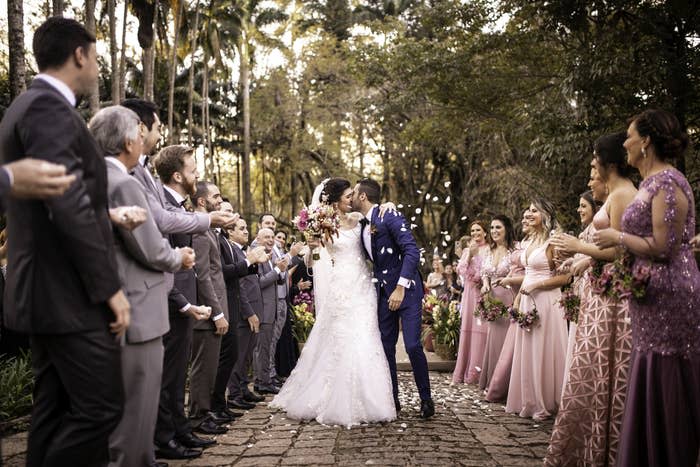 People at a wedding watching the bride and groom kiss