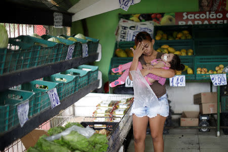 Rosana Vieira Alves, 28, holds her two-year-old, daughter Luana Vieira, who was born with microcephaly, at a supermarket in Olinda, Brazil, August 9, 2018. Rosana has three daughters. "It's hard to manage the girls. Some of them are jealous, but Luana needs more care. In time, they'll understand." Rosana does not have any family support and is overwhelmed by the cost of housing and Luana's medicines. She counts it a victory that she has managed to get a wheelchair for Luana, and worries about the four surgeries her daughter needs to correct problems with her eyes, her gut and the position of her hips and feet. The demands have taken Rosana to some dark places, and she confesses that she has considered suicide. But she still dreams of a better future, and hopes to get a degree in accounting or civil engineering. REUTERS/Ueslei Marcelino