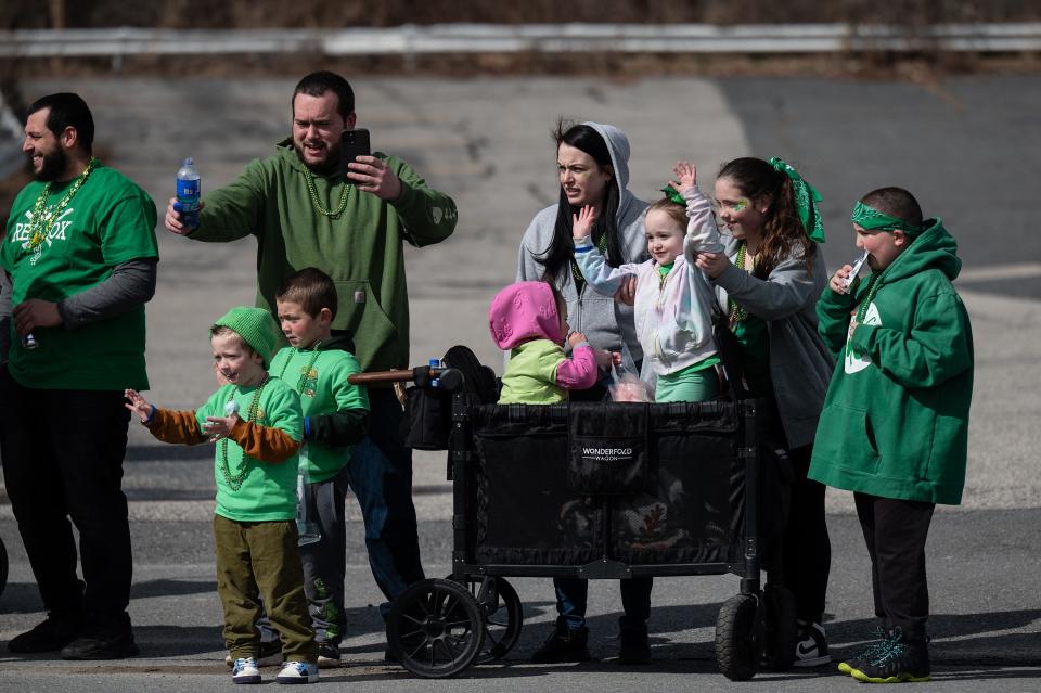 A family waves during the Worcester County St. Patrick's Parade Sunday.