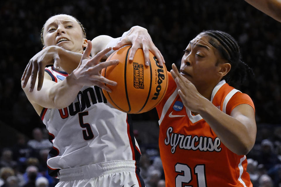 UConn guard Paige Bueckers (5) and Syracuse forward Saniaa Wilson (21) reach for a rebound in the first half of a second-round college basketball game in the NCAA Tournament, Monday, March 25, 2024, in Storrs, Conn. (AP Photo/Jessica Hill)