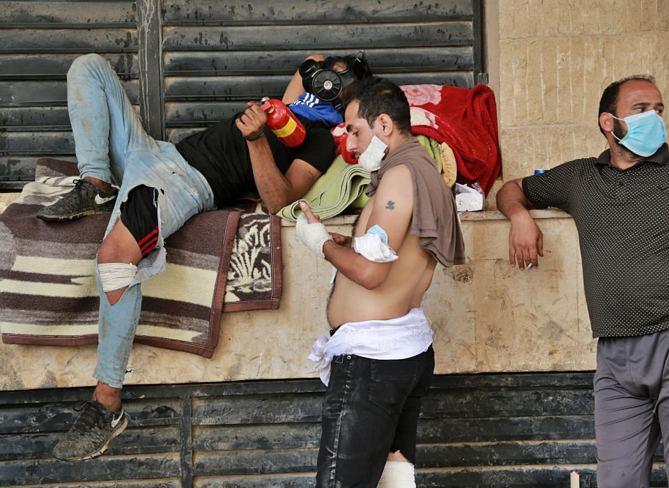 Anti-government protesters rest and look at their injuries in Tahrir Square, during a demonstration in Baghdad, Iraq, Sunday, Oct. 27, 2019. Protests have resumed in Iraq after a wave of anti-government protests earlier this month were violently put down. At least 149 people were killed in a week of demonstrations earlier in October. (AP Photo/Hadi Mizban)