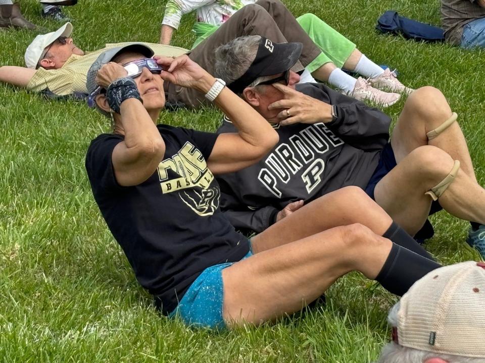 A couple relaxes on the grass at Auburn Heights Preserve in Yorklyn on Monday and waits to see the eclipse, which was visible around 3:10 p.m.