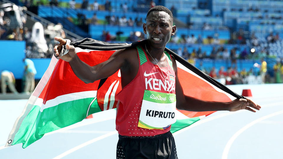 Conseslus Kipruto is seen here draped in the Kenyan flag after a race.