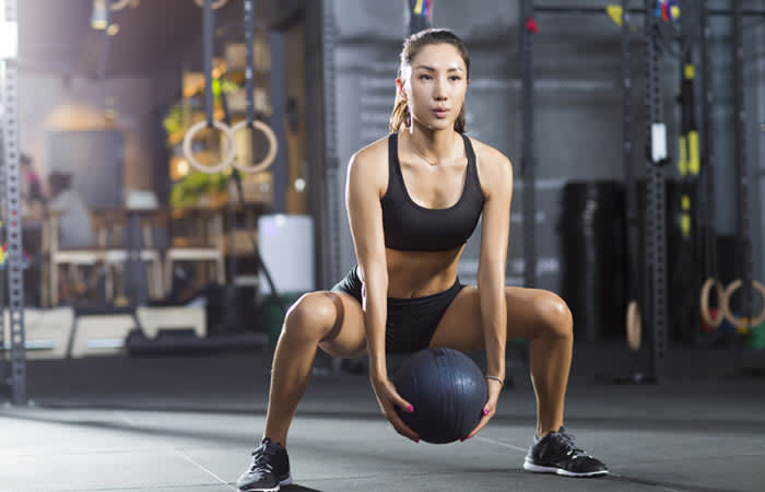 Mujer con un balón en el gimnasio