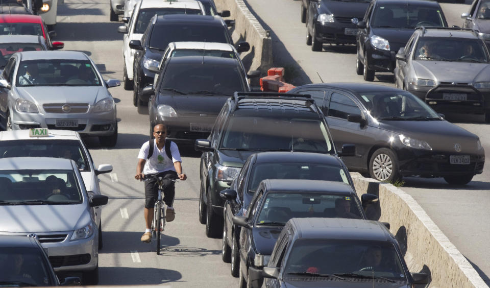 A cyclist rides past motorists stuck in traffic during a subway strike in Sao Paulo, Brazil, Wednesday, May 23, 2012. Subway workers went on strike in Brazil's biggest city on Wednesday, grinding to a halt a system used daily by more than 4 million people. Ciro Morais, a spokesman for the subway workers union, said thousands of subway workers walked off their jobs to demand a 20 percent pay hike. (AP Photo/Andre Penner)