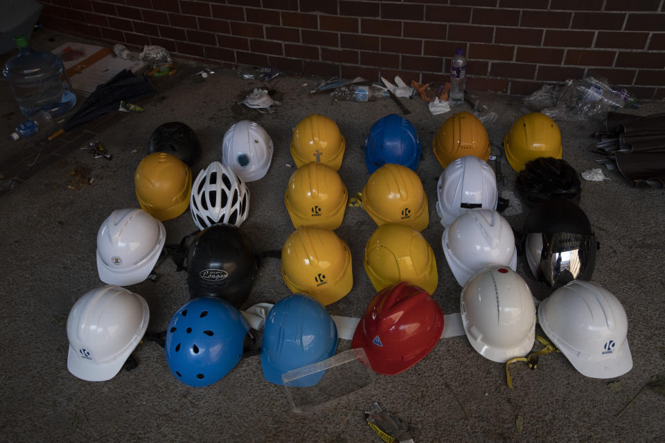 Helmets used by protesters are lined up at the Polytechnic University in Hong Kong on Wednesday, Nov. 20, 2019. A small group of protesters refused to leave Hong Kong Polytechnic University, the remnants of hundreds who took over the campus for several days. They won't leave because they would face arrest. Police have set up a cordon around the area to prevent anyone from escaping. (AP Photo/Ng Han Guan)