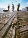 <p>Girls on splintered boardwalk, South Beach, Staten Island. (Photograph by Neal Boenzi/NYC Parks Photo Archive/Caters News) </p>