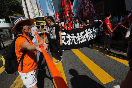 Demonstrators march in protest of the jailing of student leaders Joshua Wong, Nathan Law and Alex Chow who were imprisoned for their participation of the 2014 pro-democracy Umbrella Movement, also known as "Occupy Central" protests, in Hong Kong China August 20, 2017. Words on banner read: "Not a crime to go against totalitarianism." REUTERS/Tyrone Siu