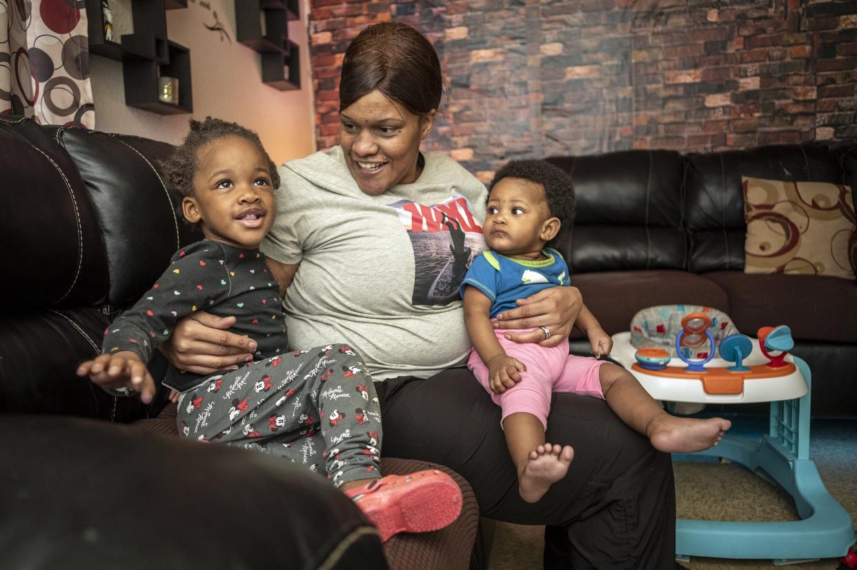 Ashley Joiner, 30, plays with two of her seven children, Gemirha Jerome, 8 months old, and Genayla Jerome, 2, at the family's apartment. Joiner lost a 3-year-old child to pneumonia, which put the family in crisis.