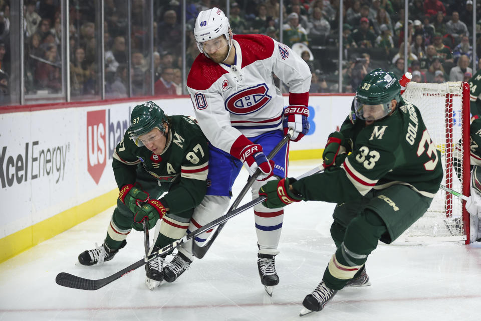 Minnesota Wild left wing Kirill Kaprizov, left, defenseman Alex Goligoski, right, and Montreal Canadiens right wing Joel Armia, middle, compete for the puck during the first period of an NHL hockey game Thursday, Dec. 21, 2023, in St Paul, Minn. (AP Photo/Matt Krohn)