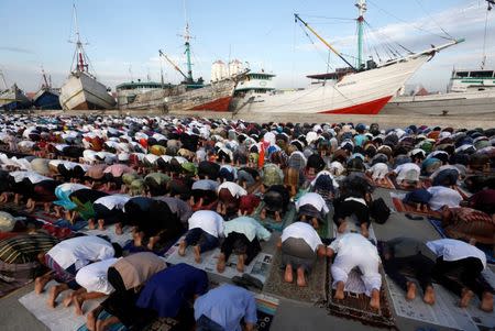 Muslims attend a Eid al-Fitr mass prayer to mark the end of the holy fasting month of Ramadan at Sunda Kelapa port in Jakarta, Indonesia, June 25, 2017. REUTERS/Agoes Rudianto