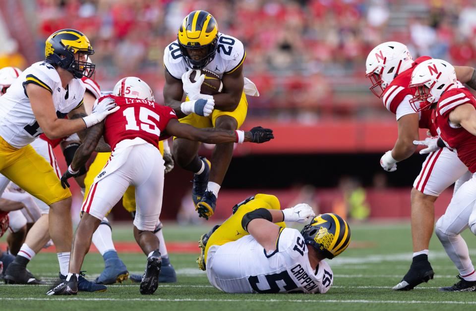 Michigan's Kalel Mullings (20) rushes against Nebraska's Tamon Lynum (15) during the second half of an NCAA college football game Saturday, Sept. 30, 2023, in Lincoln, Neb. Michigan defeated Nebraska 45-7.