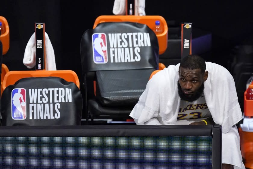 Los Angeles Lakers forward LeBron James watches play against the Denver Nuggets from the bench.