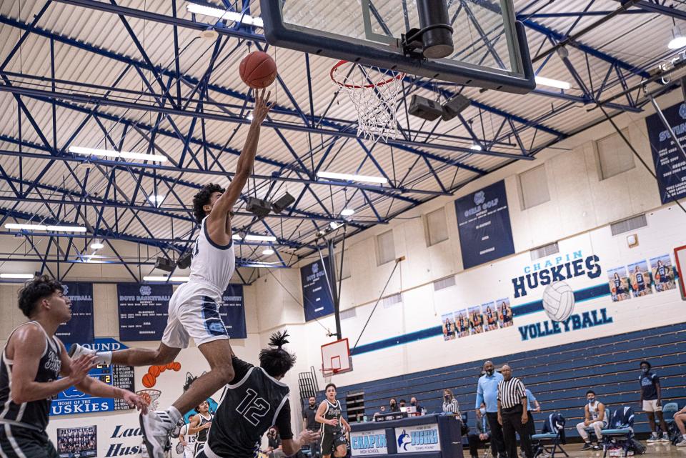 Chapin's James Holmes III dives over defenders to shoot. Chapin defeated Horizon High School 71-53 to win the Class 5A bi-district championship at Chapin High School on Feb. 19, 2021.