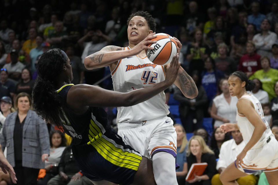 Dallas Wings center Kalani Brown, left, falls backward while defending against Phoenix Mercury's Brittney Griner (42) during the second half of a WNBA basketball game Wednesday, June 7, 2023, in Arlington, Texas. (AP Photo/Tony Gutierrez)