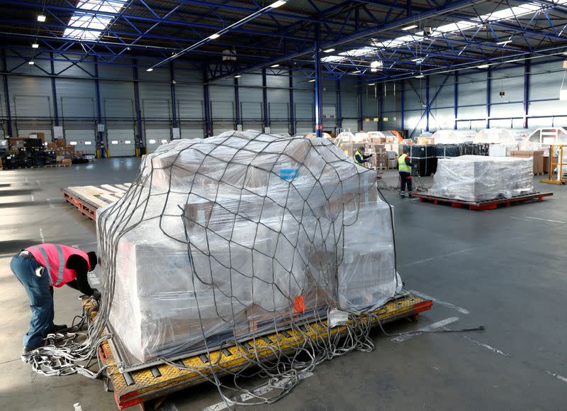 A worker preprares to load medical supplies in a cargo aircraft at Liege airport