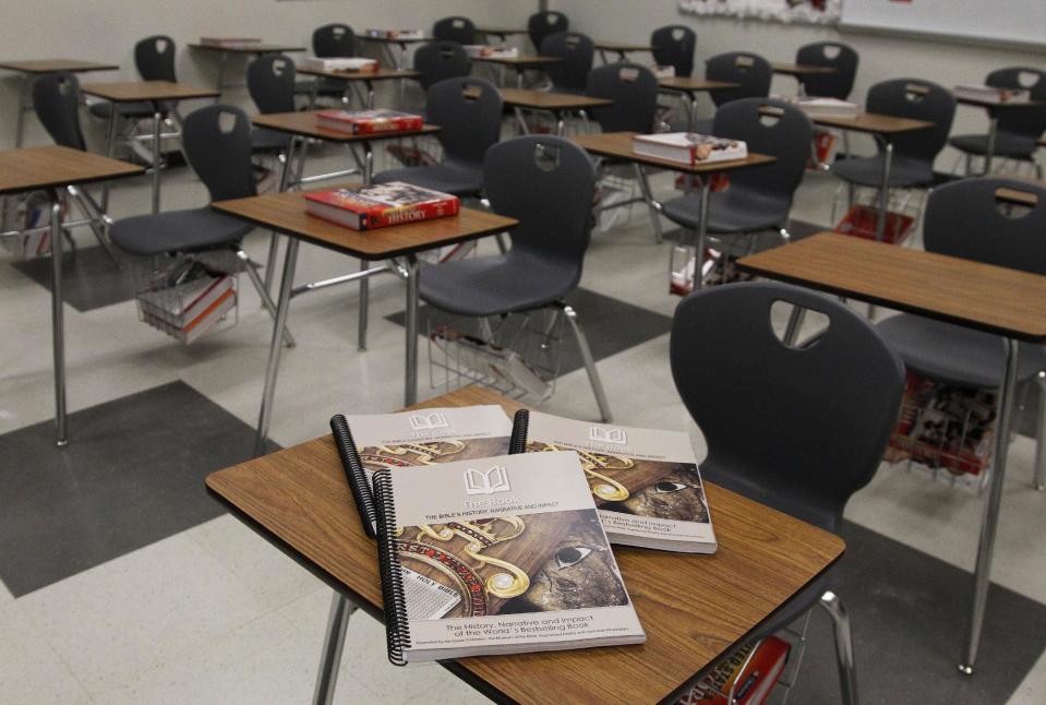 This Friday, April 18, 2014 photo shows a textbook by the Museum of the Bible which will be used for a new elective course starting in Fall 2014 at the suburban Oklahoma City Mustang School District high school in Mustang, Okla. The curriculum, supported by Hobby Lobby chain president Steve Green and billed as a way to teach archaeology, history and the arts through Bible stories, also tells students God is always there in times of trouble and that sinners must "suffer the consequences" of disobeying. (AP Photo/Sue Ogrocki)