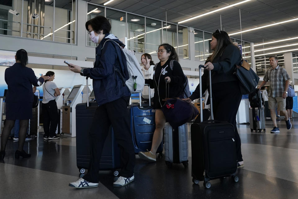 Travelers walk through Terminal 3 at O'Hare International Airport in Chicago, Thursday, Aug. 31, 2023. The Federal Aviation Administration predicts that this will be the third busiest holiday weekend of the year so far, behind only the Juneteenth weekend, which included Father's Day, and the Presidents Day break.(AP Photo/Nam Y. Huh)