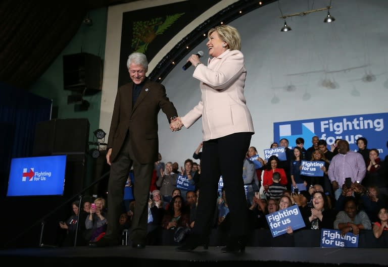 Democratic presidential candidate Hillary Clinton (R) and her husband, former US president Bill Clinton, greet supporters during a "get out the caucus" event in Davenport, Iowa