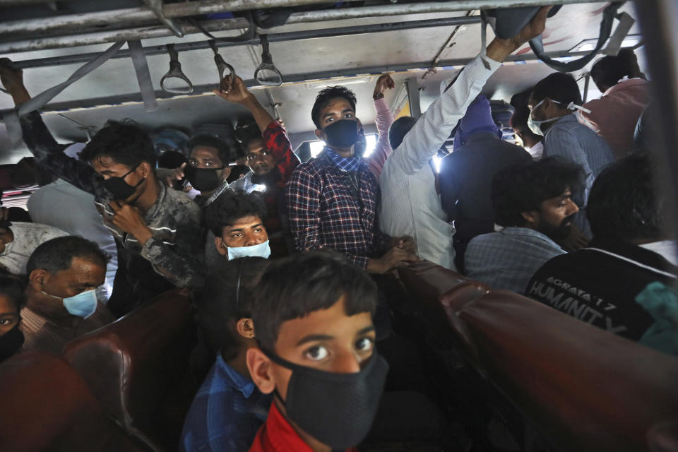 In this Friday, March 27, 2020, file photo, migrant daily wage laborers crowd a bus as they travel to their respective hometowns following a lockdown amid concern over spread of coronavirus in New Delhi, India. Over the past week, India’s migrant workers - the mainstay of the country’s labor force - spilled out of big cities that have been shuttered due to the coronavirus and returned to their villages, sparking fears that the virus could spread to the countryside. It was an exodus unlike anything seen in India since the 1947 Partition, when British colothe subcontinent, with the 21-day lockdown leaving millions of migrants with no choice but to return to their home villages. (AP Photo/Manish Swarup, File)