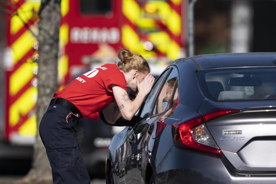 A first responder checks a parked car at the scene of a mass shooting at a Walmart, Wednesday, Nov. 23, 2022, in Chesapeake, Va. A Walmart manager opened fire on fellow employees in the break room of the Virginia store, killing several people in the country’s second high-profile mass shooting in four days, police and witnesses said Wednesday. (AP Photo/Alex Brandon)