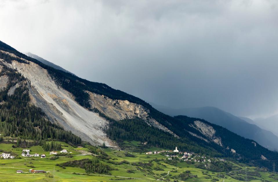 lush green grass in front of a dark mountain and rainclouds in Brienz-Brinzauls, Switzerland