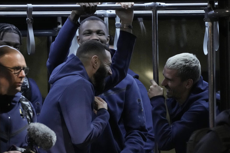 Karim Benzema, left, of France's national soccer team laughs with his teammate Antoine Griezmann, right, upon their team arrival at Hamad International airport in Doha, Qatar, Wednesday, Nov. 16, 2022 ahead of the upcoming World Cup. France will play their first match in the World Cup against Australia on Nov. 22. (AP Photo/Hassan Ammar)