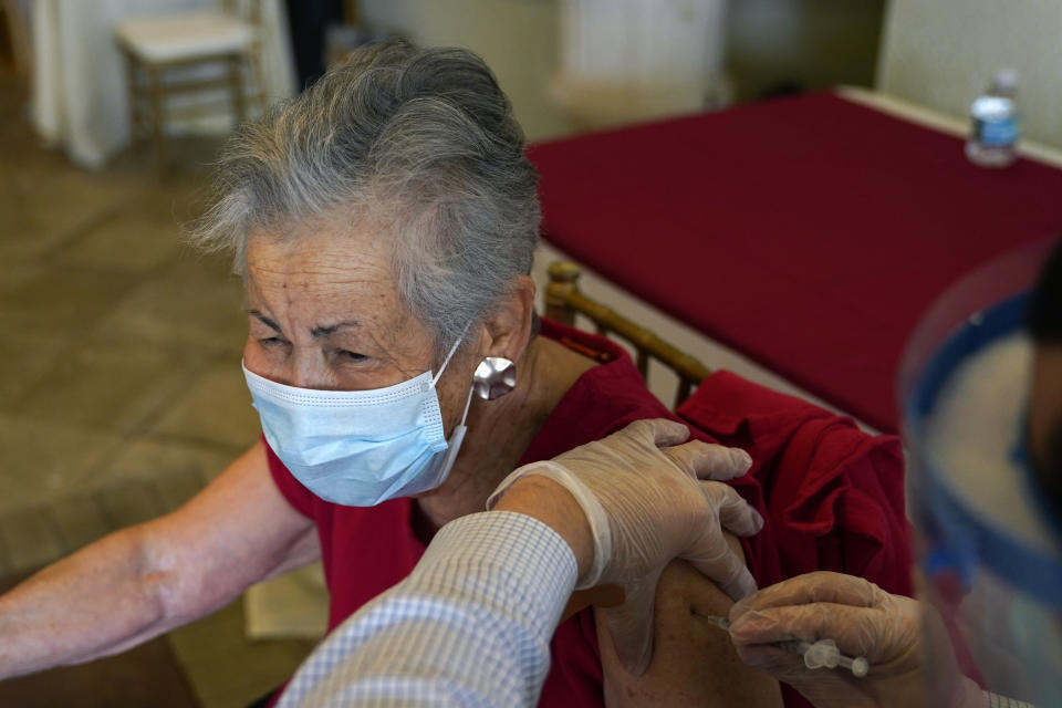Resident Gail Nanning, 83, receives the Pfizer-BioNTech COVID-19 vaccine at the The Palace assisted living facility, Tuesday, Jan. 12, 2021, in Coral Gables, Fla. (AP Photo/Lynne Sladky)