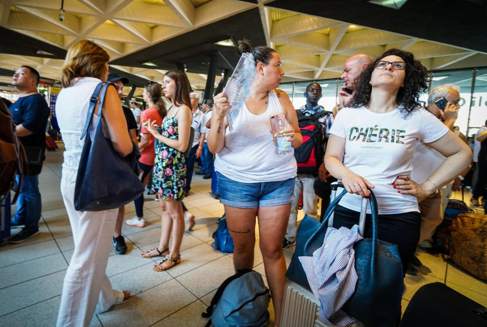 Passengers check train times at Naples' Central station, southern Italy, Monday, July 22, 2019. A suspected arson fire has forced cancellations of at least 42 high-speed trains in Italy on the heavily-traveled Milan-Naples corridor. (Cesare Abbate/ANSA via AP)