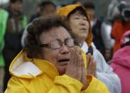 One of relatives of passengers aboard a sunken ferry cries during a Buddhist ceremony to pray for speedy rescue and their safety at a port in Jindo, south of Seoul, South Korea, Friday, April 18, 2014. The ferry flipped onto its side and filled with water off the southern coast of South Korea on Wednesday, with about 270 people still missing. (AP Photo/Lee Jin-man)