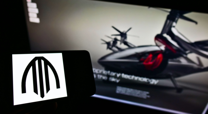 Person holding smartphone with logo of US air taxi company Archer Aviation (ACHR) on screen in front of website. Focus on phone display. Unmodified photo.