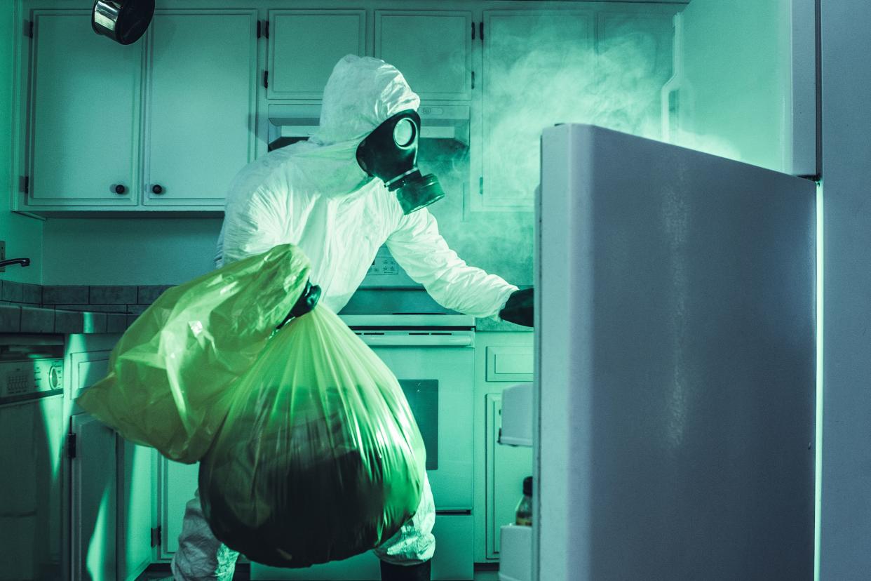 dirty refrigerator cleaning in hazmat suit