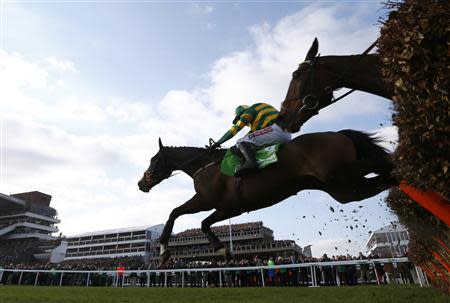 Jockey Barry Geraghty riding Jezki clears the final fence on the way to winning the Champion Hurdle Challenge Trophy at the Cheltenham Festival horse racing meet in Gloucestershire, western England March 11, 2014. REUTERS/Eddie Keogh