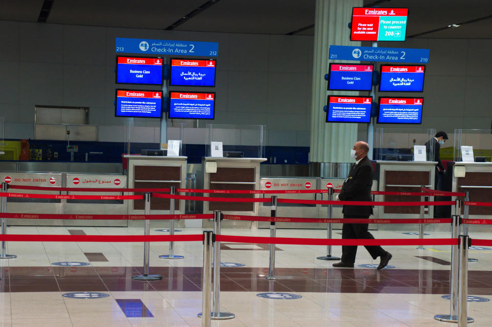 Employees of the long-haul carrier Emirates wearing masks due to the coronavirus pandemic prepare to greet passengers at Dubai International Airport's Terminal 3 in Dubai, United Arab Emirates, Wednesday, June 10, 2020. The coronavirus pandemic has hit global aviation hard, particularly at Dubai International Airport, the world's busiest for international travel, due to restrictions on global movement over the virus. (AP Photo/Jon Gambrell)