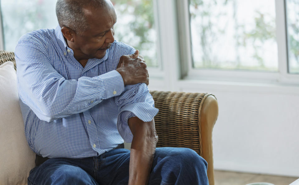 older man grabbing his arm