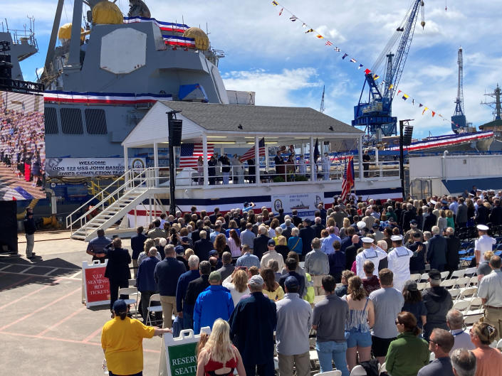 A crowd gathers for a christening ceremony for the future USS Basilone, which is in the background, on Saturday, June 18, at Bath Iron Works in Bath, Maine. The christening of a Navy destroyer on Saturday highlighted the sacrifices of two generations — the ship’s namesake killed in World War II and another Marine who died more than 60 years later. The future USS Basilone bears the name of a Marine who was awarded the Medal of Honor before his death on Iwo Jima. (AP Photo/David Sharp)
