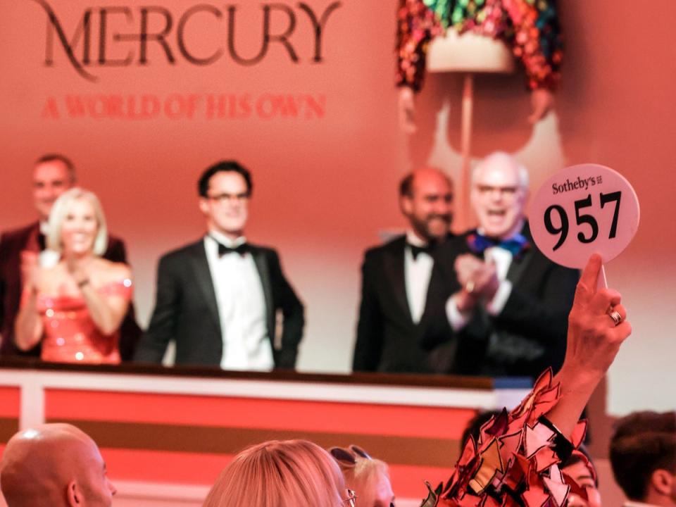 A woman wearing an exact replica bids on Freddie Mercury’s iconic rainbow jacket (Tristan Fewings/Getty for Sotheby's)