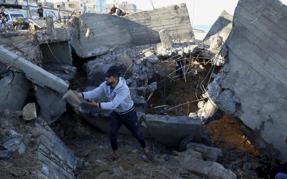 A resident removes the rubble of destroyed sewage pipes following overnight Israeli missile strikes, along the beach of Shati refugee camp, in Gaza City, Thursday, Feb. 6, 2020. Earlier on Wednesday, Israel struck Hamas militant targets in Gaza in response to rocket fire toward Israeli communities the previous night. (AP Photo/Adel Hana)