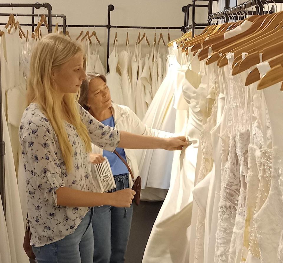 Emily Crawford and her mother, Lisa, look over wedding dresses at the Ivory Room during a Pop-in Shop Expansion Celebration. With wedding bells ringing in the near future for Crawford, it was an opportunity to see what is available.