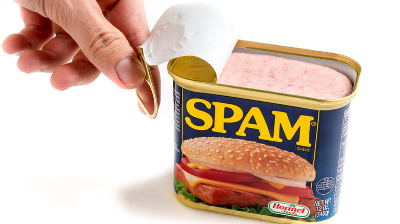 hand opening Spam can