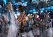 2016 Rio Olympics - Closing ceremony - Maracana - Rio de Janeiro, Brazil - 21/08/2016. Participants wear raincoats as they tale part in the closing ceremony. REUTERS/Stoyan Nenov