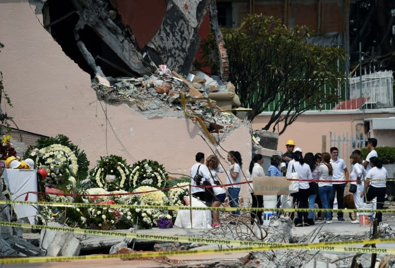 Wreaths are placed to honor the dead on the site where a building was flattened by the 7.1-magnitude quake in Mexico City on September 26, 2017