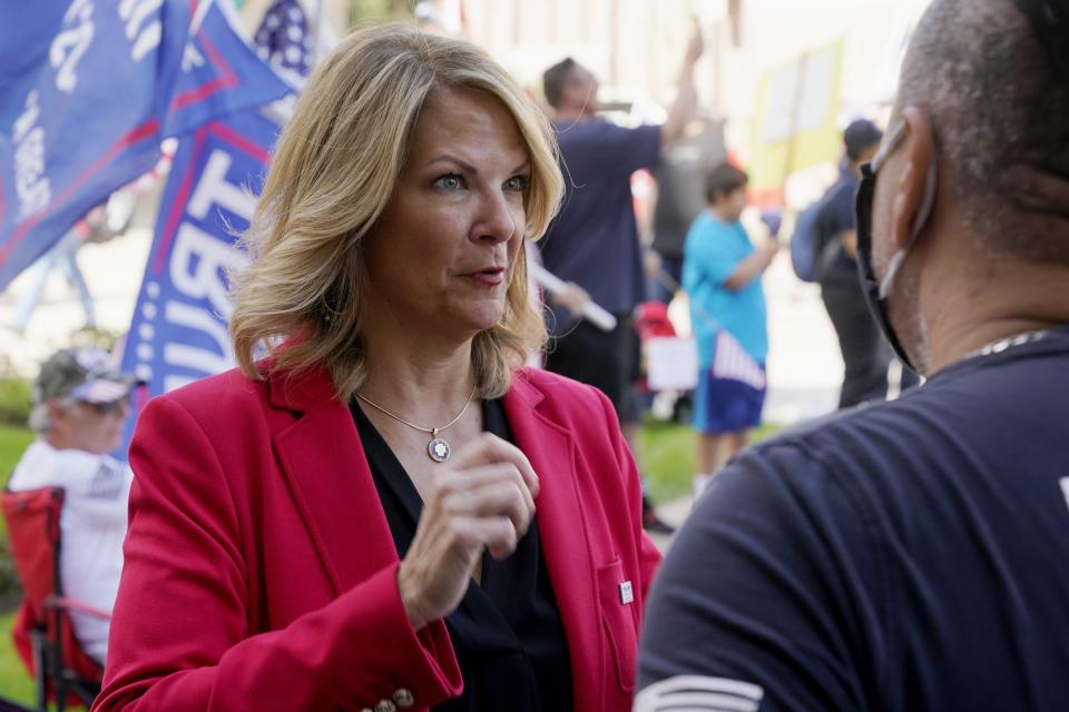 FILE - Dr. Kelli Ward, left, chair of the Arizona Republican Party, talks with a supporter of President Donald Trump as they join the crowd at a rally outside the Arizona Capitol, Nov. 7, 2020, in Phoenix. Ward is one of 11 Republicans in Arizona who submitted a document to Congress falsely declaring Donald Trump had beaten Joe Biden in the state during the 2020 presidential election were charged Wednesday, April 24, 2024 with conspiracy, fraud and forgery, marking the fourth state to bring charges against "fake electors." (AP Photo/Ross D. Franklin, File)