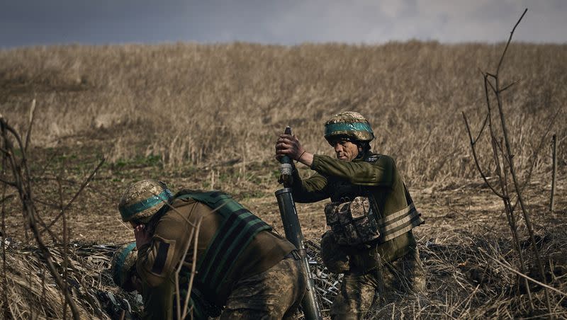 Ukrainian soldiers of the 28th Brigade fire a mortar at Russian positions on the frontline near Bakhmut, Donetsk region, Ukraine, Monday, March 27, 2023.