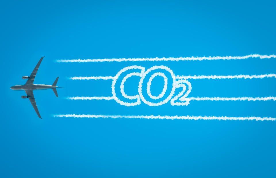 Airplane leaving jet contrails with CO2 word inside. Suitable for ecofriendly and sustainable journey concepts and the negative impact on the environment.