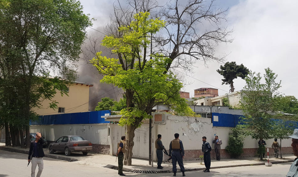Afghan security personnel watch as smoke rises after a huge explosion near the offices of the attorney general in Kabul, Afghanistan, Wednesday, May 8, 2019. Two police officials say Wednesday's explosion was followed by a gunbattle between militants and security forces. (AP Photo/Rahmat Gul)