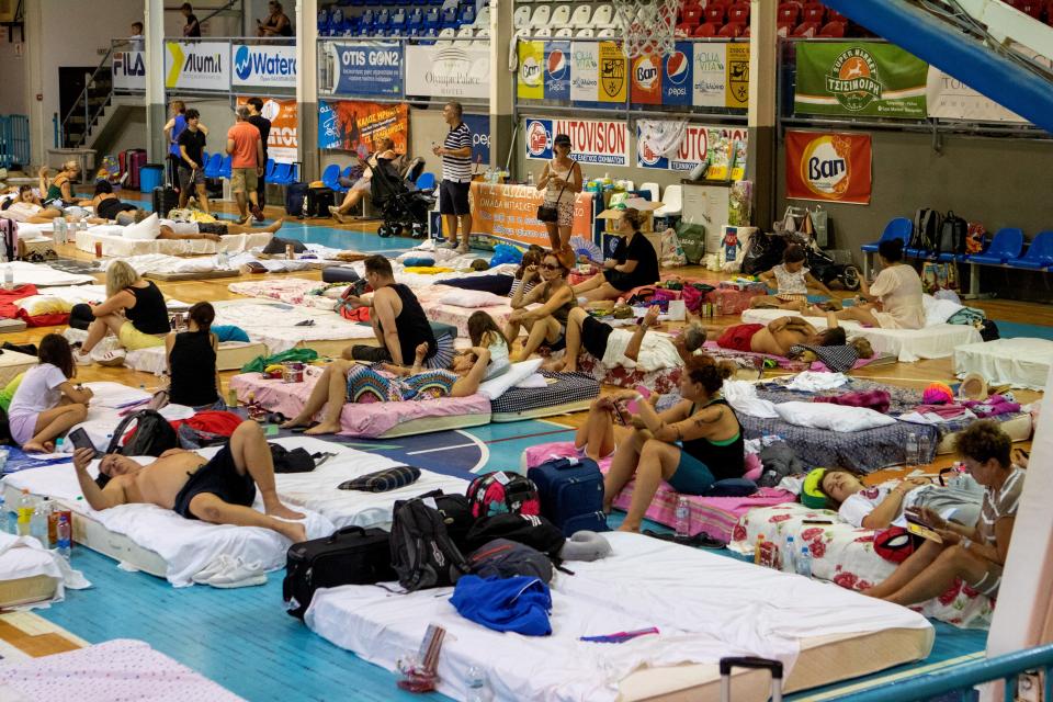 Tourists and residents are also resting  in Venetokleio sports Arena, which is converted into a shelter after a wildfire (EPA)