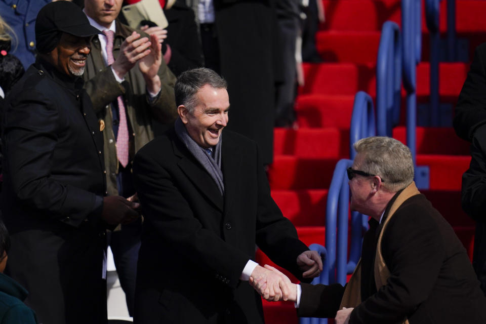 Virginia Gov. Ralph Northam heads to his seat before an inauguration ceremony for Gov. elect Glenn Youngkin, Saturday, Jan. 15, 2022, in Richmond, Va. (AP Photo/Julio Cortez)