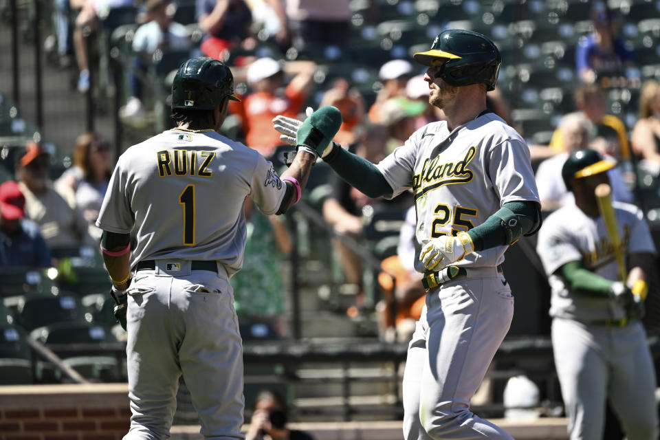 Oakland Athletics Brent Rooker (25) is greeted by Esteury Ruiz (1) after hitting a three run home run against Baltimore Orioles starting pitcher Cole Irvin during the third inning of a baseball game, Thursday, April 13, 2023, in Baltimore. (AP Photo/Terrance Williams)